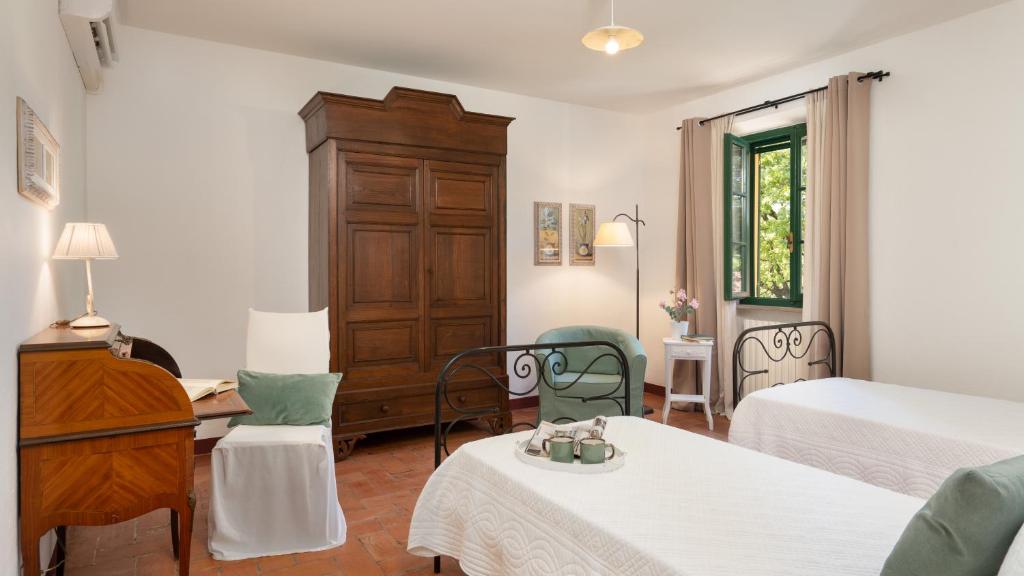 - une chambre avec 2 lits, un bureau et une commode dans l'établissement Podere Capanna - Il Tuo Rifugio di Relax nella Campagna Toscana, à Montecatini Val di Cecina