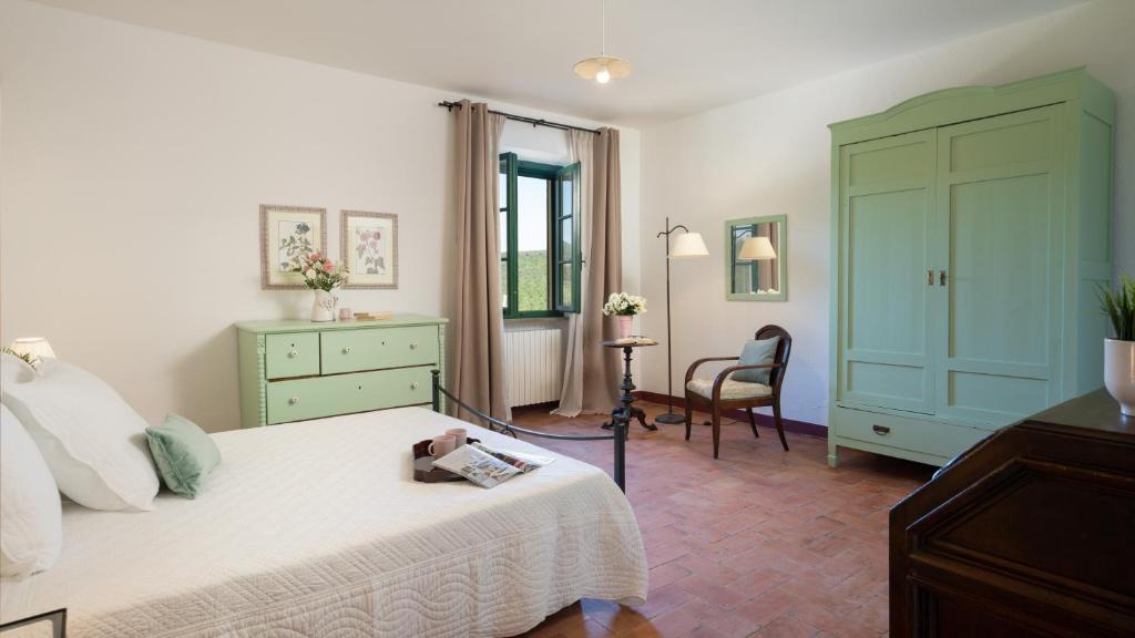 une chambre avec un lit, une commode et une chaise dans l'établissement Podere Capanna - Il Tuo Rifugio di Relax nella Campagna Toscana, à Montecatini Val di Cecina 10 autres photos