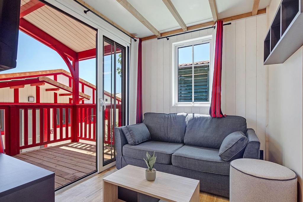 d'un salon avec un canapé et un balcon. dans l'établissement Camping Domaine Berrua - Maeva Sélection, à Bidart