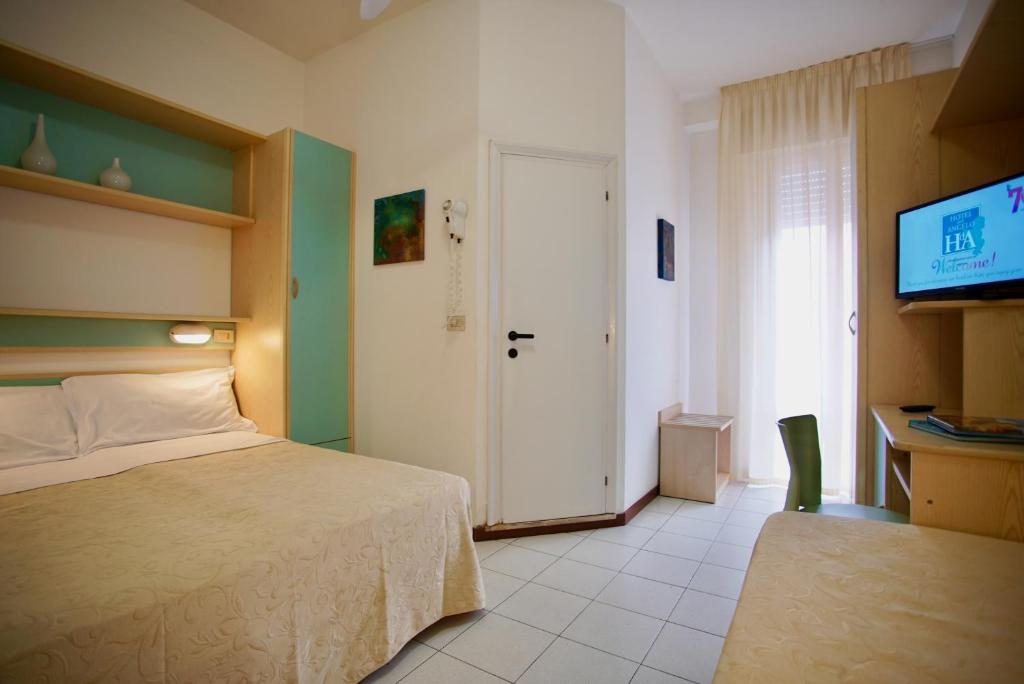 - une chambre avec un lit, une télévision et une porte dans l'établissement Hotel Dell'Angelo, à Rimini