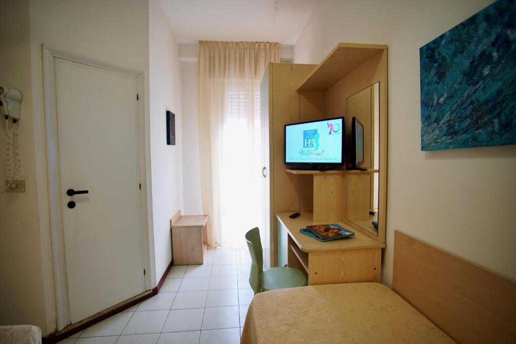 une chambre avec un lit, une télévision et un bureau dans l'établissement Hotel Dell'Angelo, à Rimini