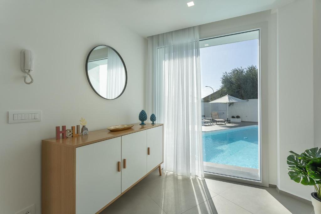 - une salle de bains blanche avec un miroir et une piscine dans l'établissement Villa Iside, à Marina di Ragusa 31 autres photos
