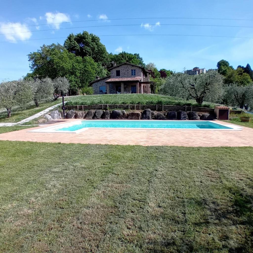 une piscine devant une maison dans l'établissement villa il sasseto, à Castel Viscardo