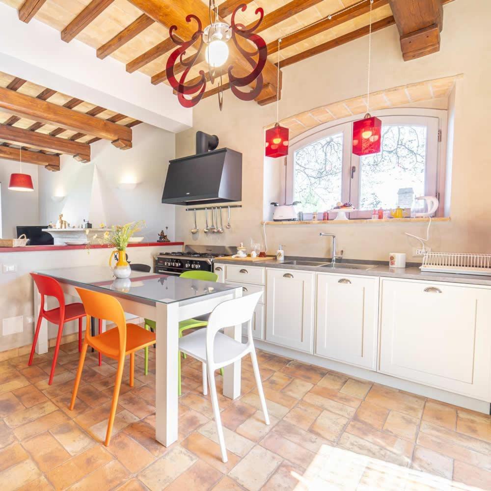 une cuisine avec une table et des chaises dans une pièce dans l'établissement villa il sasseto, à Castel Viscardo 11 autres photos