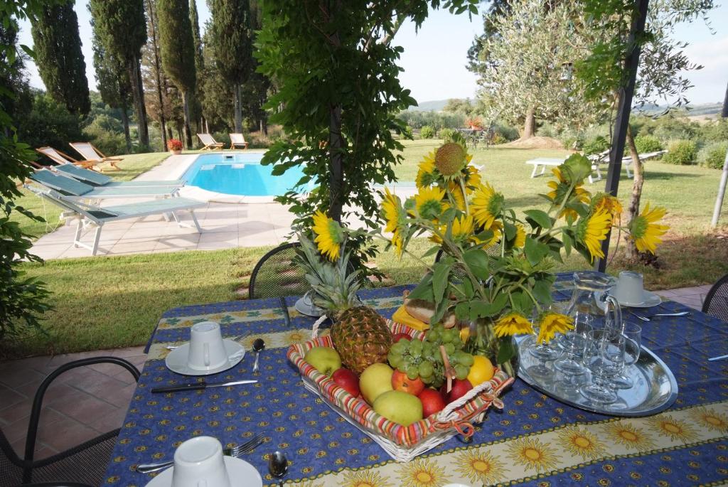 une table bleue avec une corbeille de fruits sur elle dans l'établissement Podere Suvignano, à Murlo