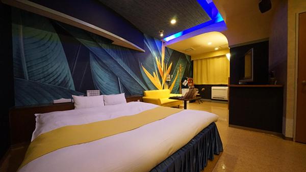 une chambre avec un grand lit dans une pièce dans l'établissement Hotel Dolphin, à Ishinomaki