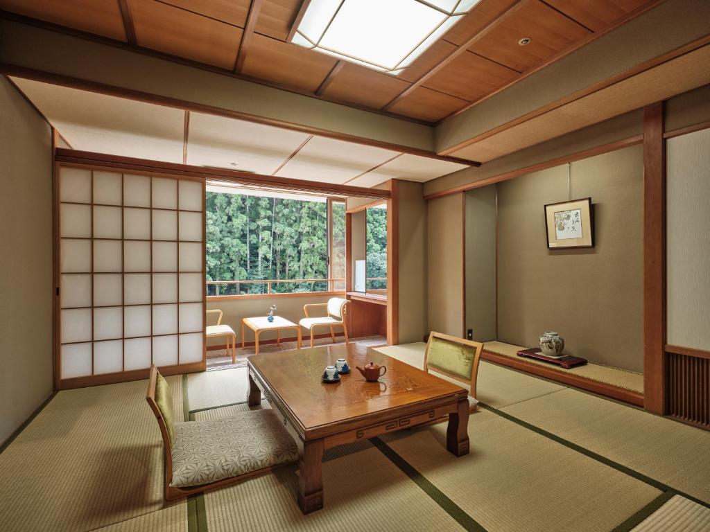une pièce avec une table, des chaises et une fenêtre dans l'établissement Sansuikan Kawayu Midoriya, à Hongu
