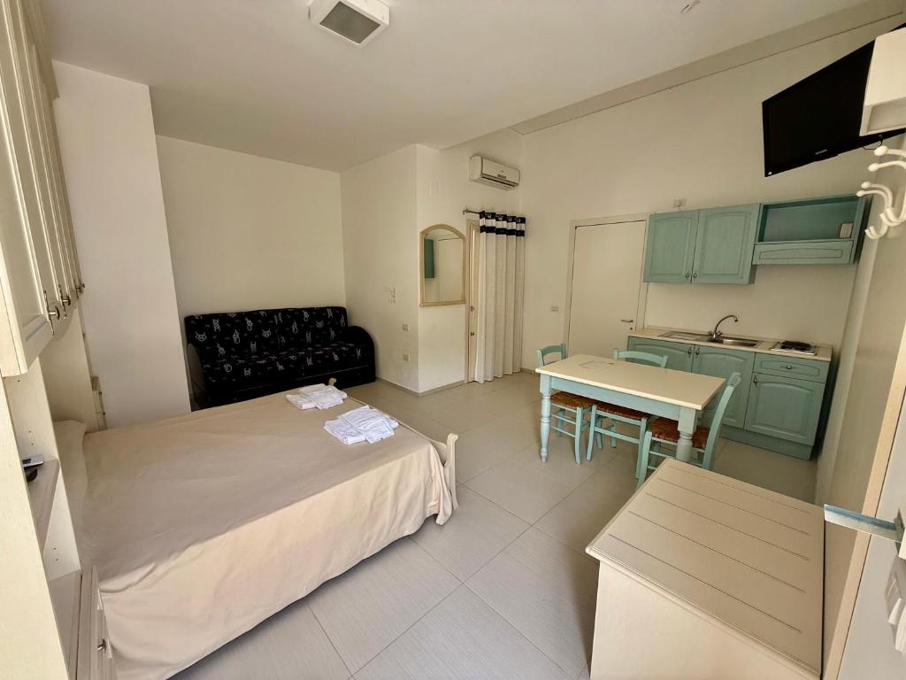 une petite chambre avec un lit et une cuisine dans l'établissement Baia Sangiorgio Hotel & Beach Club, à Bari