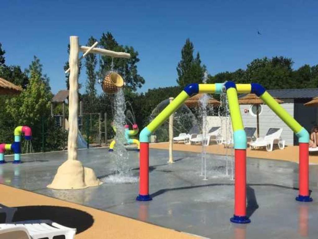- un parc aquatique avec un toboggan coloré dans l'établissement Camping 4 étoiles - Piscine - eehi00, à Aubigny
