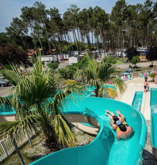 une femme utilisant un toboggan aquatique dans l'établissement Chez Bruno & Sophie Mobil home luxe 6-8P BORA BORA, à Saint-Julien-en-Born