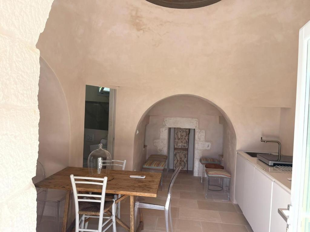 une cuisine et une salle à manger avec une table et des chaises dans l'établissement Luxury Trullo Ostuni, à Ostuni