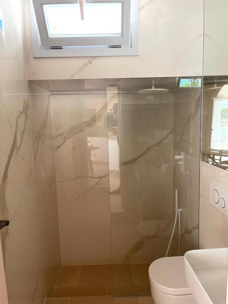 une salle de bain avec toilettes et fenêtre dans l'établissement Luxury Trullo Ostuni, à Ostuni