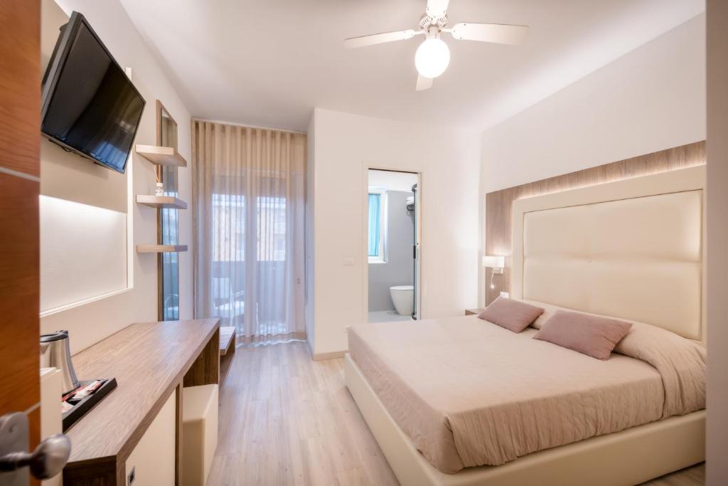 une chambre avec un lit et une télévision à écran plat dans l'établissement All'Orologio - Boutique Hotel, à Caorle 232 autres photos