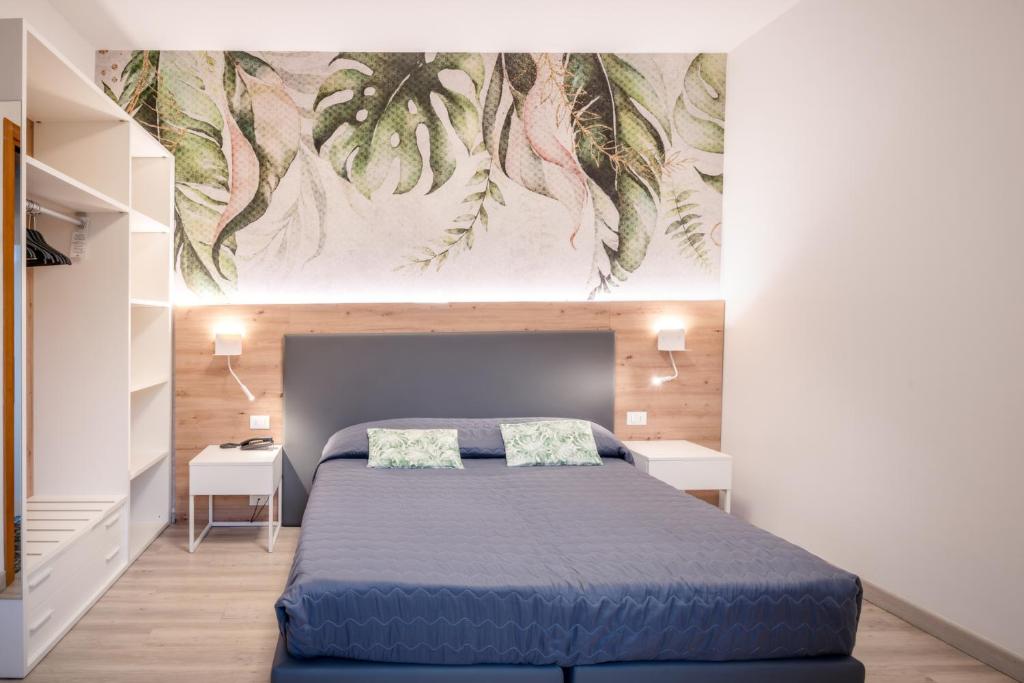 - une chambre dotée d'un lit bleu et d'une peinture murale dans l'établissement All'Orologio - Boutique Hotel, à Caorle
