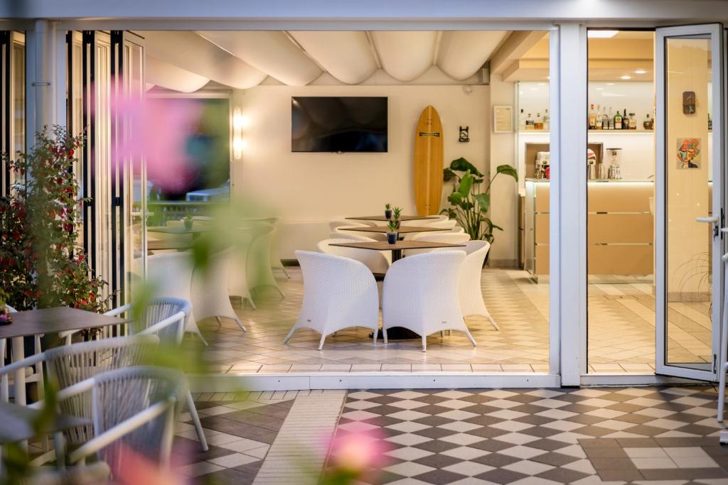 une salle à manger avec une table et des chaises blanches dans l'établissement All'Orologio - Boutique Hotel, à Caorle