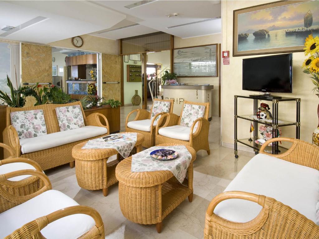 Il comprend un salon doté d'un mobilier en osier et d'une télévision à écran plat. dans l'établissement Hotel Gloria, à Gabicce Mare