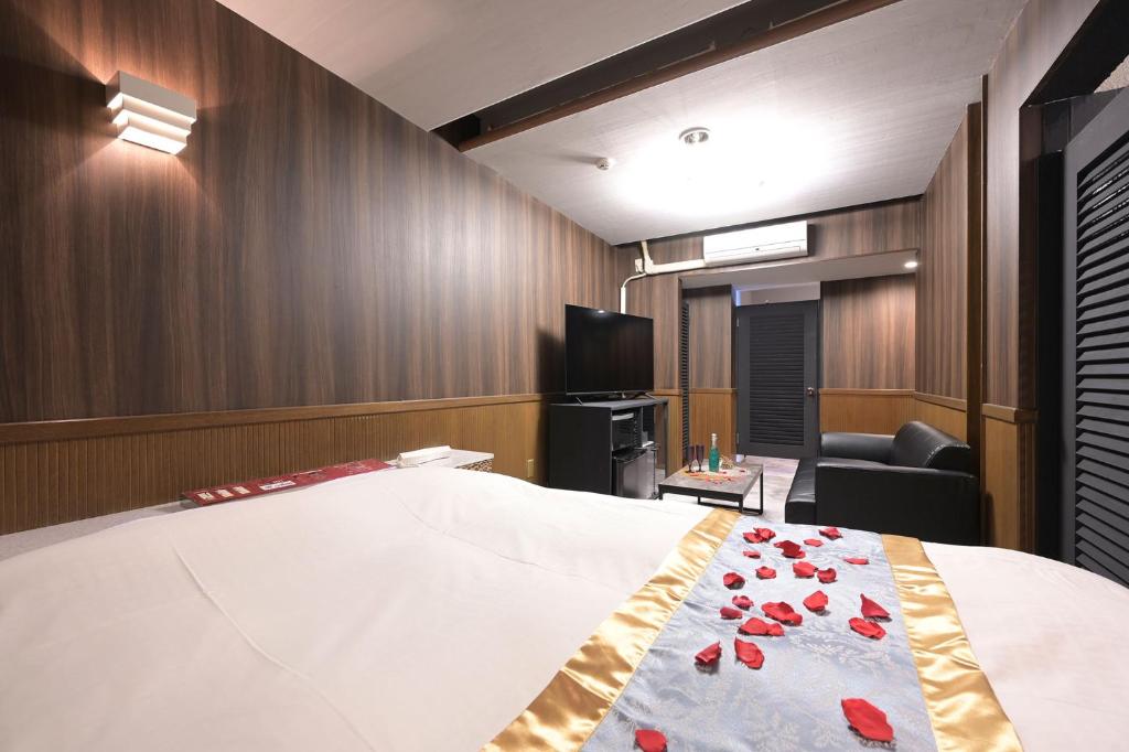 - une chambre avec un lit orné de roses rouges dans l'établissement Hotel NEO, à Honjo