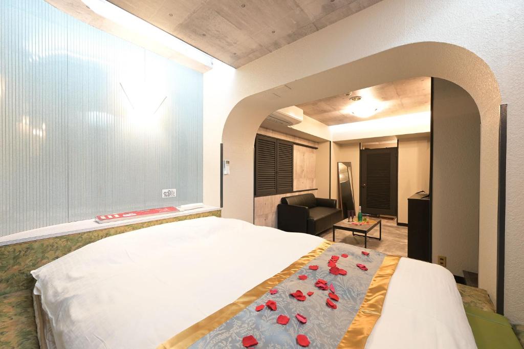 une chambre avec un lit et un salon dans l'établissement Hotel NEO, à Honjo