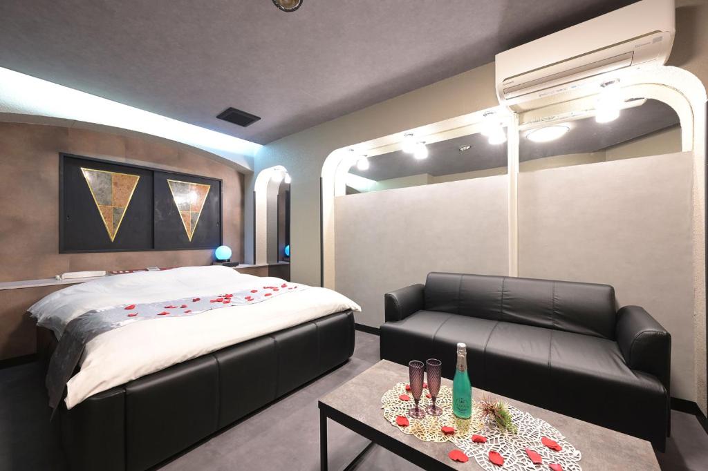 une chambre avec un lit, un canapé et une table dans l'établissement Hotel NEO, à Honjo