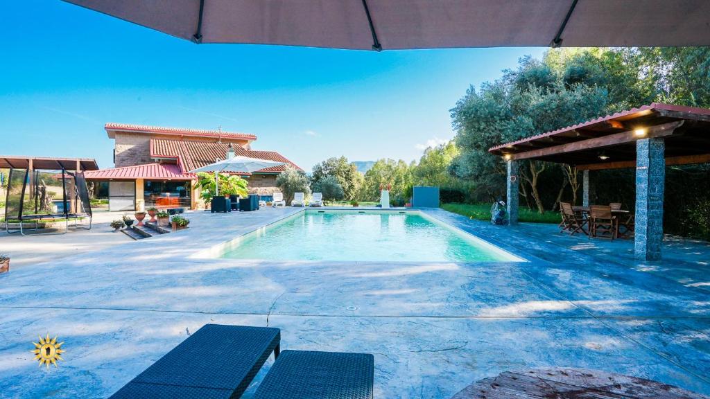 une piscine avec deux chaises et un pavillon dans l'établissement Villa Gambula - Relax and Pool, à Perdaxius 99 autres photos