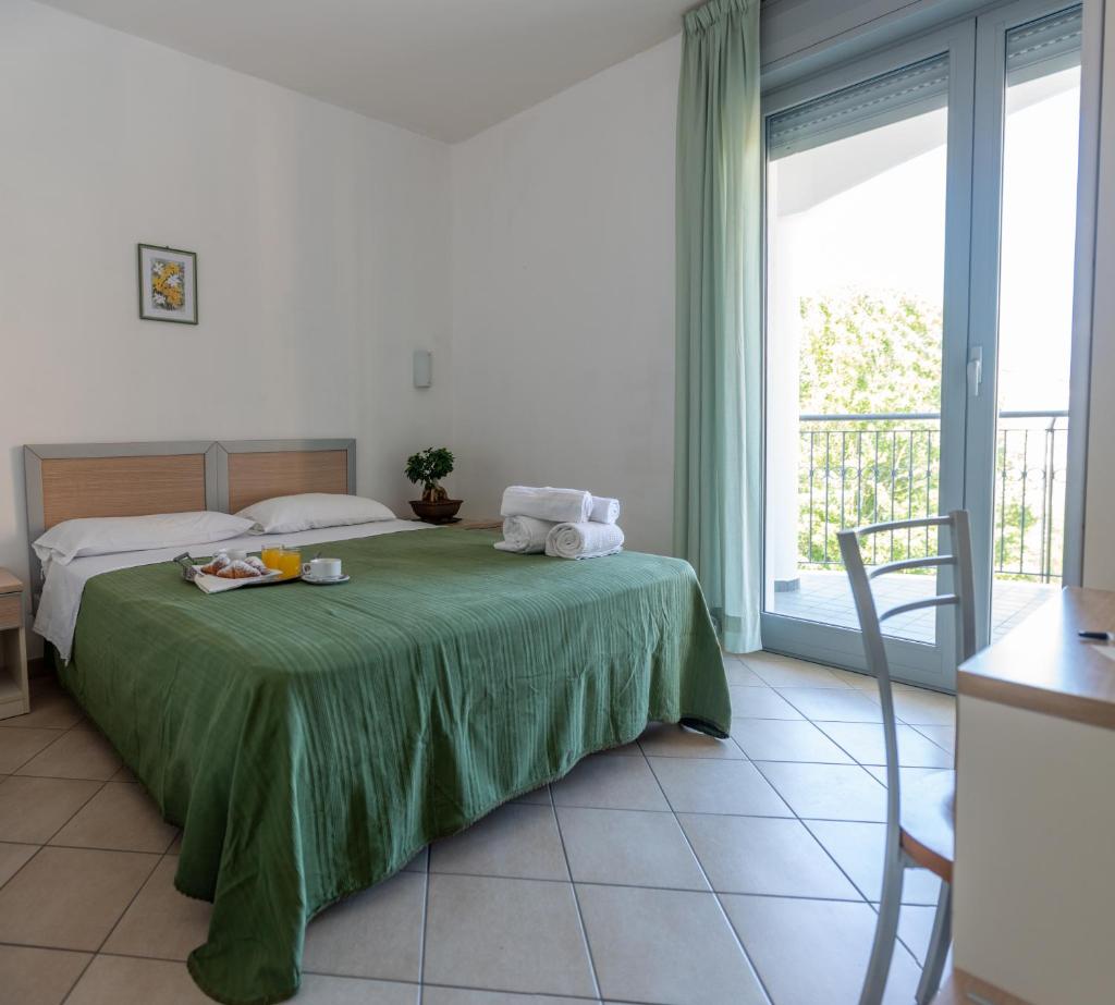 une chambre avec un lit et une grande fenêtre dans l'établissement Altamira Residence, à Roseto degli Abruzzi