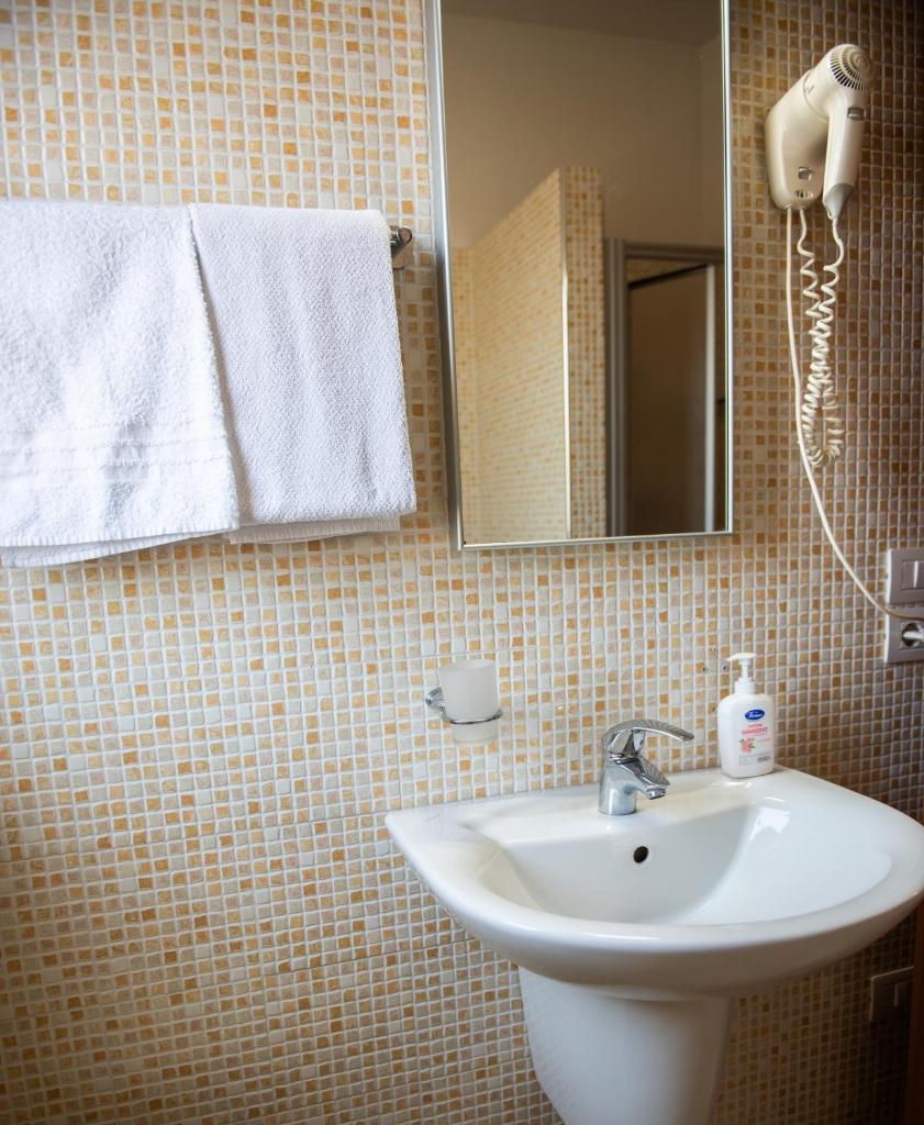 une salle de bain avec un lavabo, un miroir et des serviettes dans l'établissement Altamira Residence, à Roseto degli Abruzzi 29 autres photos