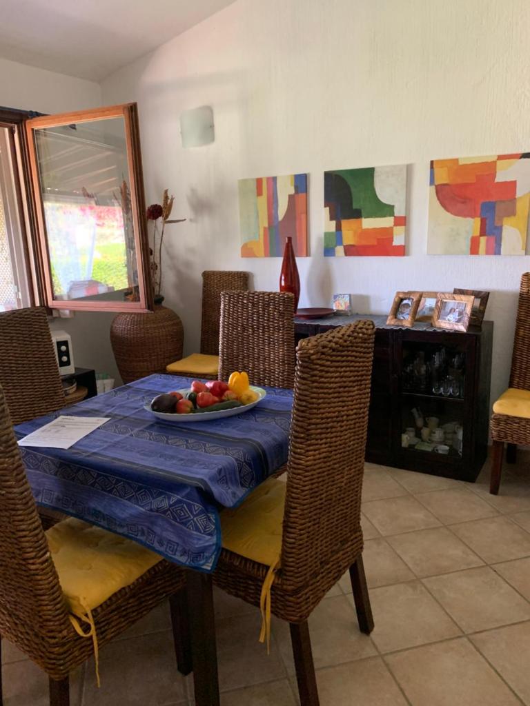 une salle à manger avec une table avec un bol de fruits dessus dans l'établissement Villa EMPATJA, à Tertenìa