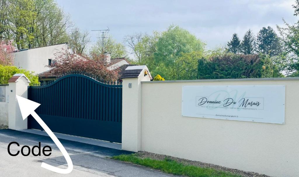une clôture noire et blanche avec un panneau dessus dans l'établissement Cabane insolite 2 p Jacuzzi Domaine du Marais 91 Magnolia, à Maisse