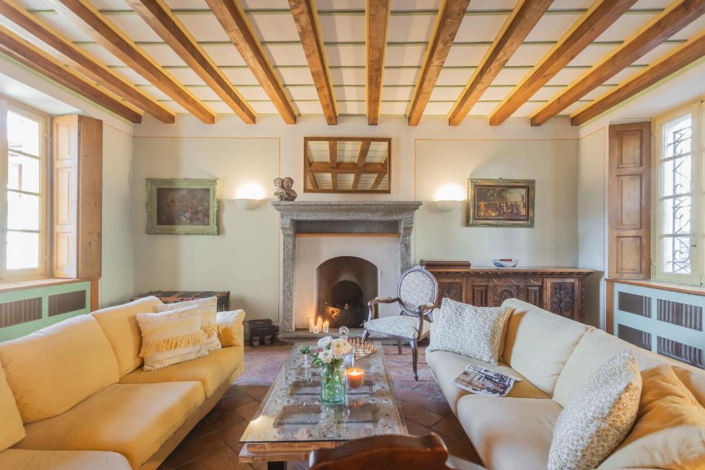 un salon avec des canapés et une cheminée dans l'établissement Villa Torre di Palanzo with Magnificent View by Rent All Como, à Faggeto Lario