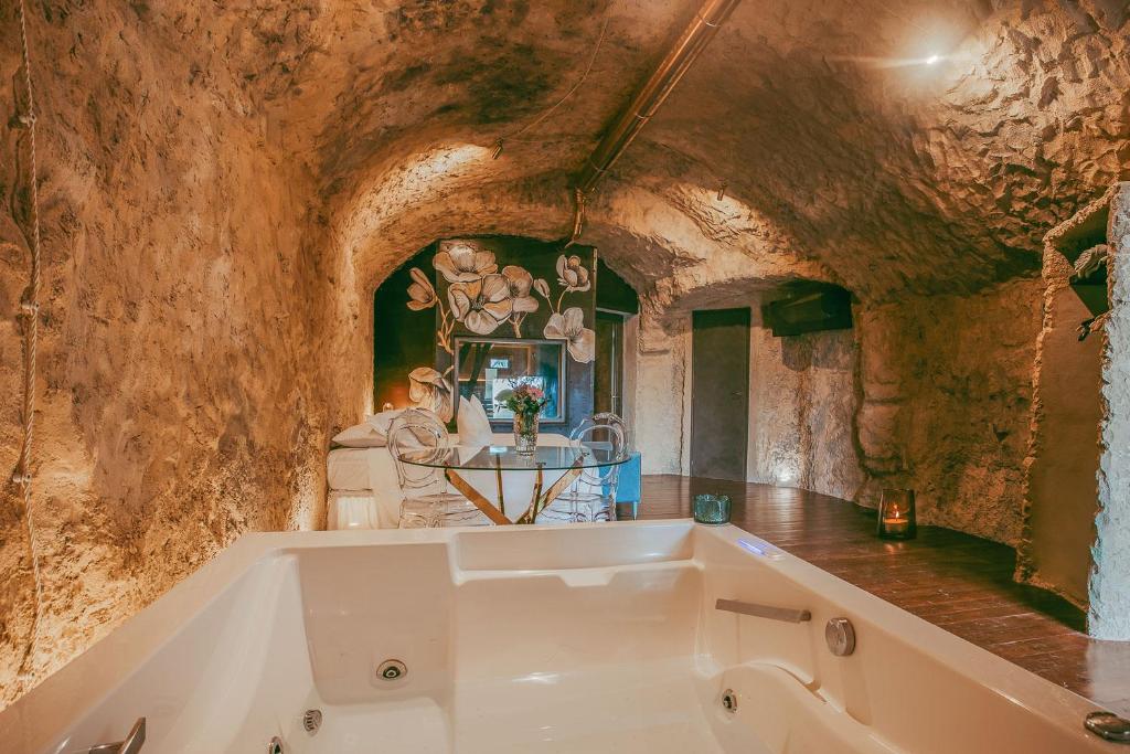 une baignoire dans une pièce avec un mur en pierre dans l'établissement Torre Collevento Luxury Villa, à Orvieto
