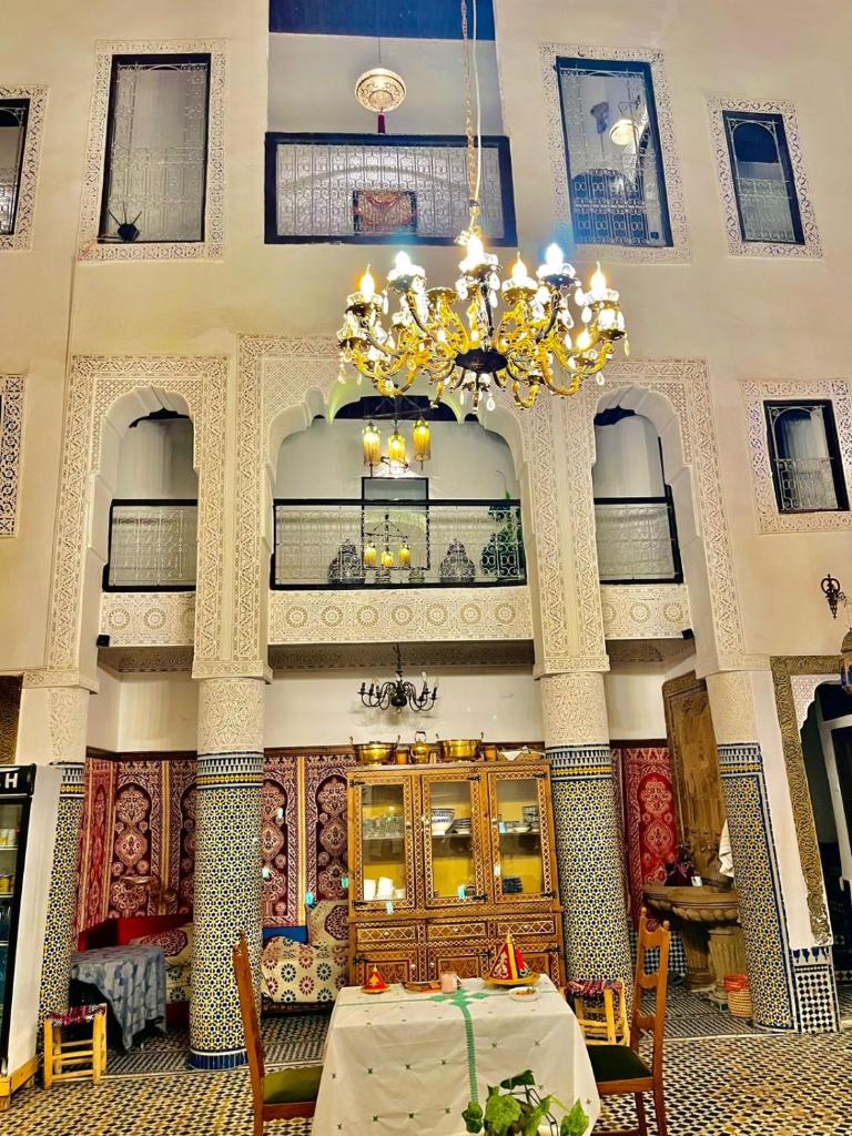 Cette grande chambre comprend une table et un lustre. dans l'établissement Riad Lalla Zoubida, à Fès 37 autres photos