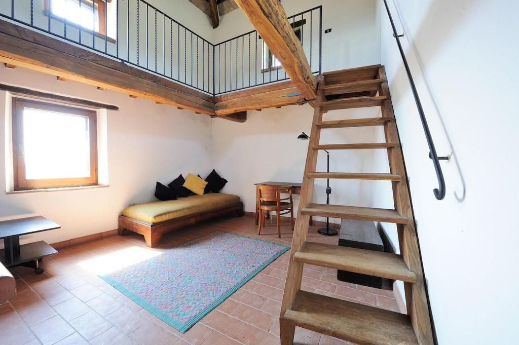 un salon avec une échelle et un canapé dans l'établissement Antico Casale in pietra con Piscina privata, à Monte Molino