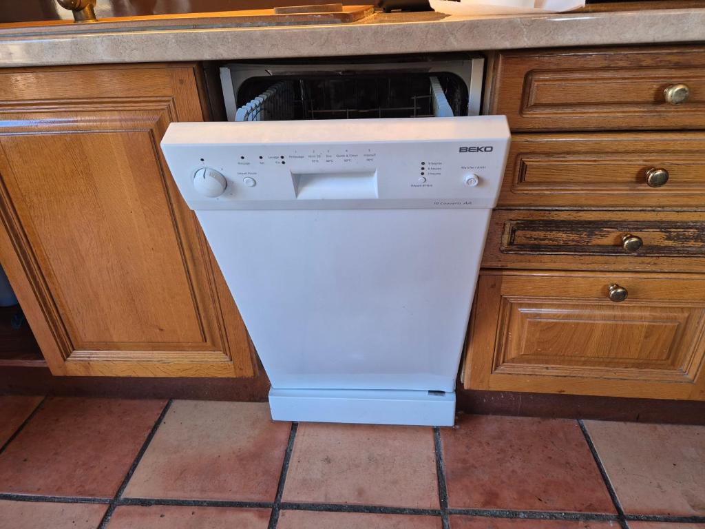 - un lave-vaisselle blanc dans la cuisine sous un comptoir dans l'établissement Sur Un Petit Nuage, à Roubion
