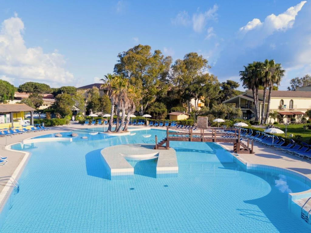 une grande piscine dans un complexe dans l'établissement Hotel surrounded by greenery with swimming pool in Arborea just 600 meters from the sea, à Arborea