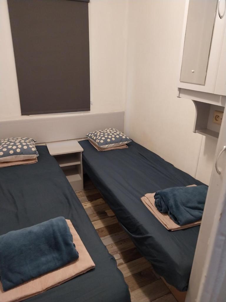 - 2 lits dans une petite chambre avec des draps bleus dans l'établissement SAS CAMPING PARC MONTANA, à Gassin