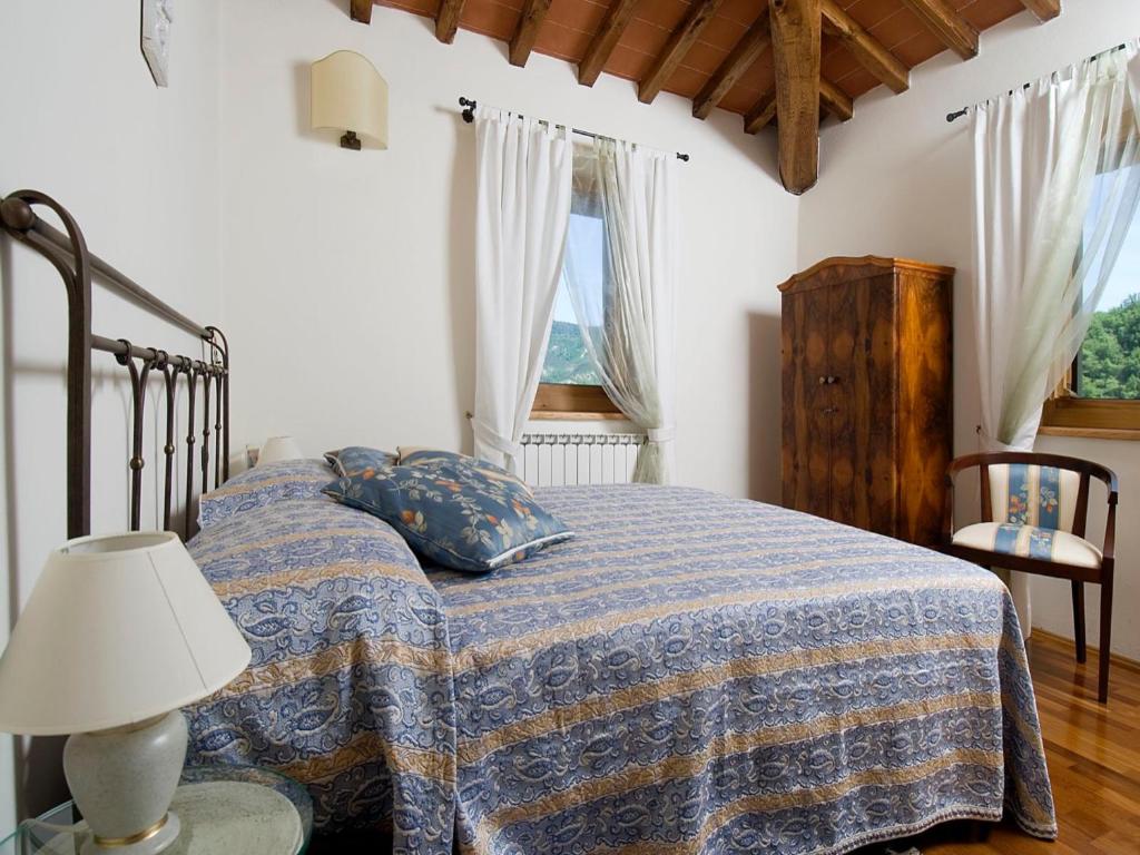 - une chambre avec un lit doté d'une couverture bleue et d'une lampe dans l'établissement Villa La Fonte 13, à San Godenzo
