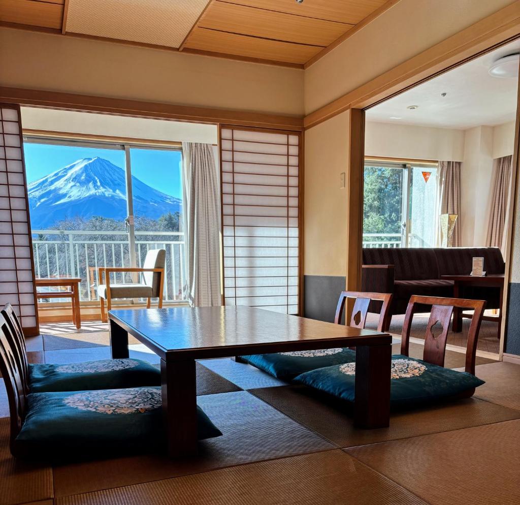- un salon avec une table et une vue sur la montagne dans l'établissement Fuji View Hotel, à Fujikawaguchiko
