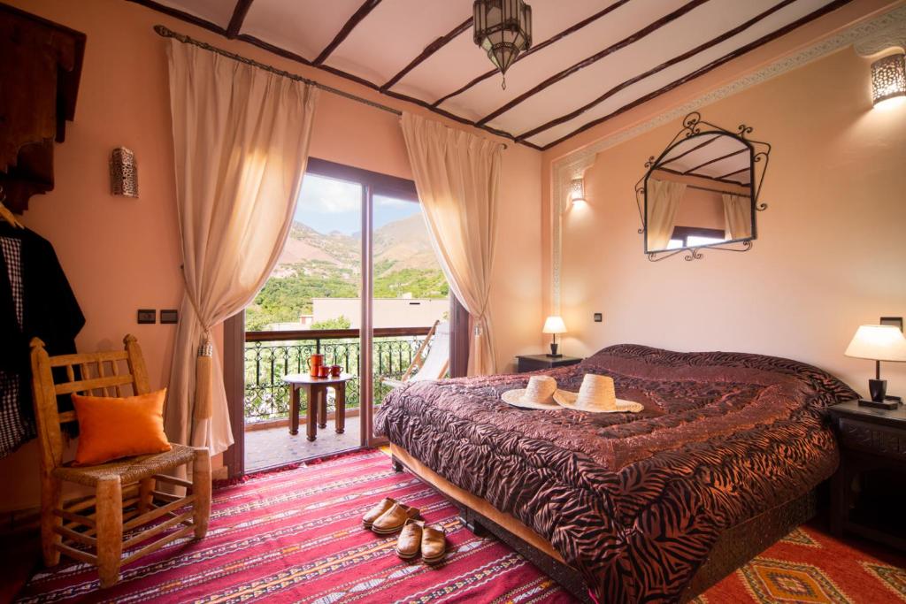 une chambre avec un lit et un balcon dans l'établissement Riad Atlas Toubkal, à Imlil