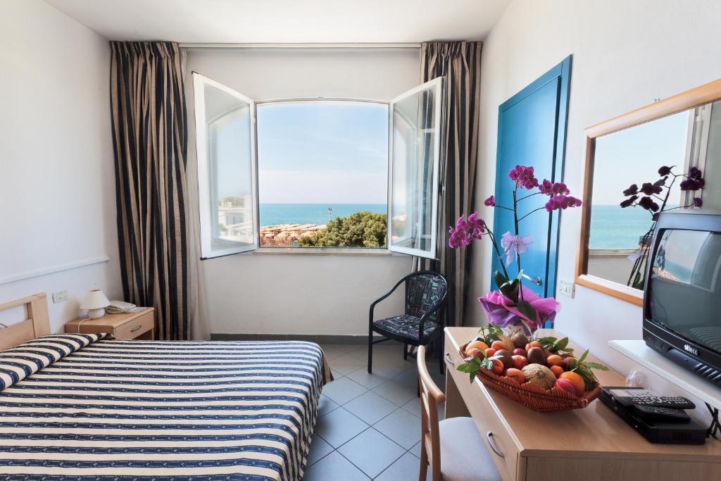 une chambre d'hôtel avec un lit et une vue sur l'océan dans l'établissement HG Hotel Il Settebello, à Marina di Cecina