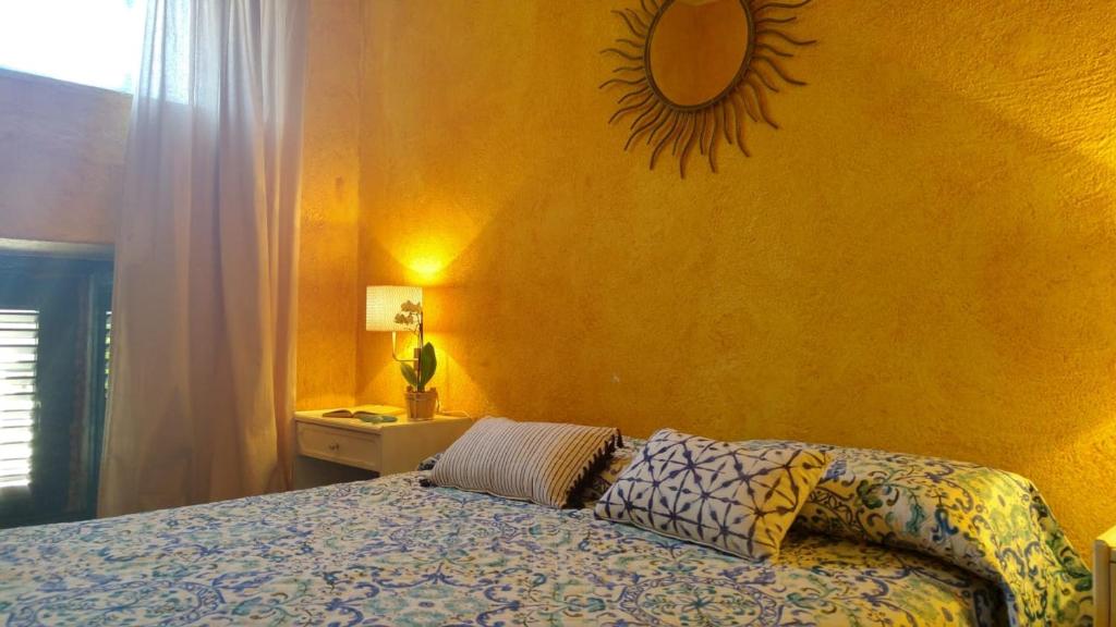 une chambre avec un lit et un miroir au mur dans l'établissement Casa il Faro villa con piscina, à Castelmola 37 autres photos