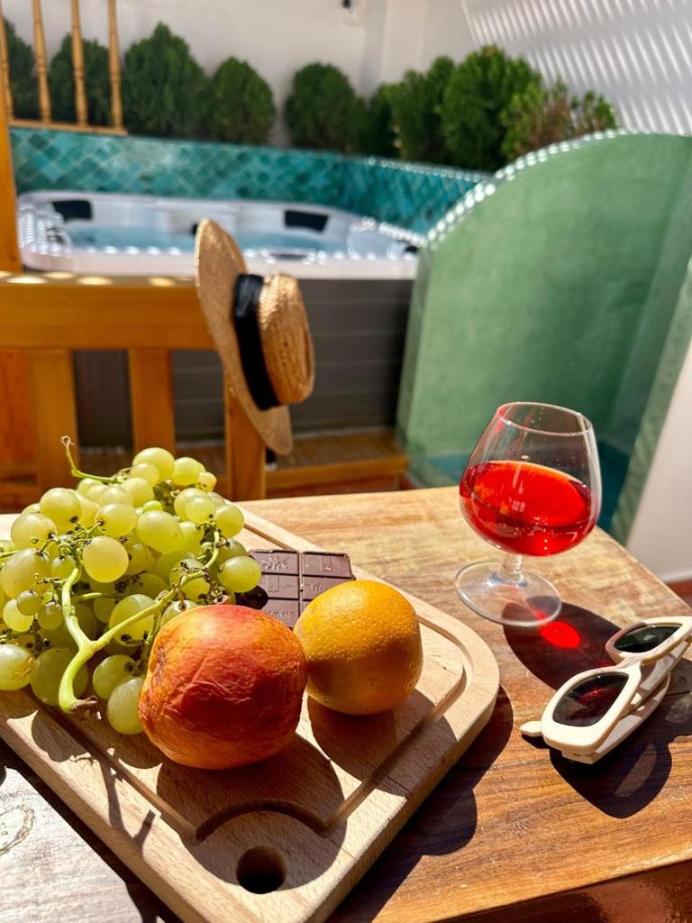 une assiette de raisins et un verre de vin sur une table dans l'établissement Riad Madinina, à Marrakech 37 autres photos