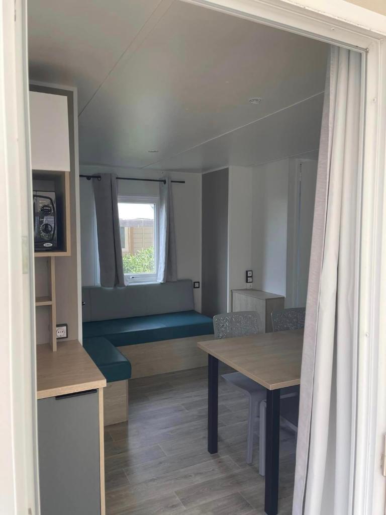 une chambre avec un canapé, une table et une fenêtre dans l'établissement Mobil-home premium 325, à Narbonne