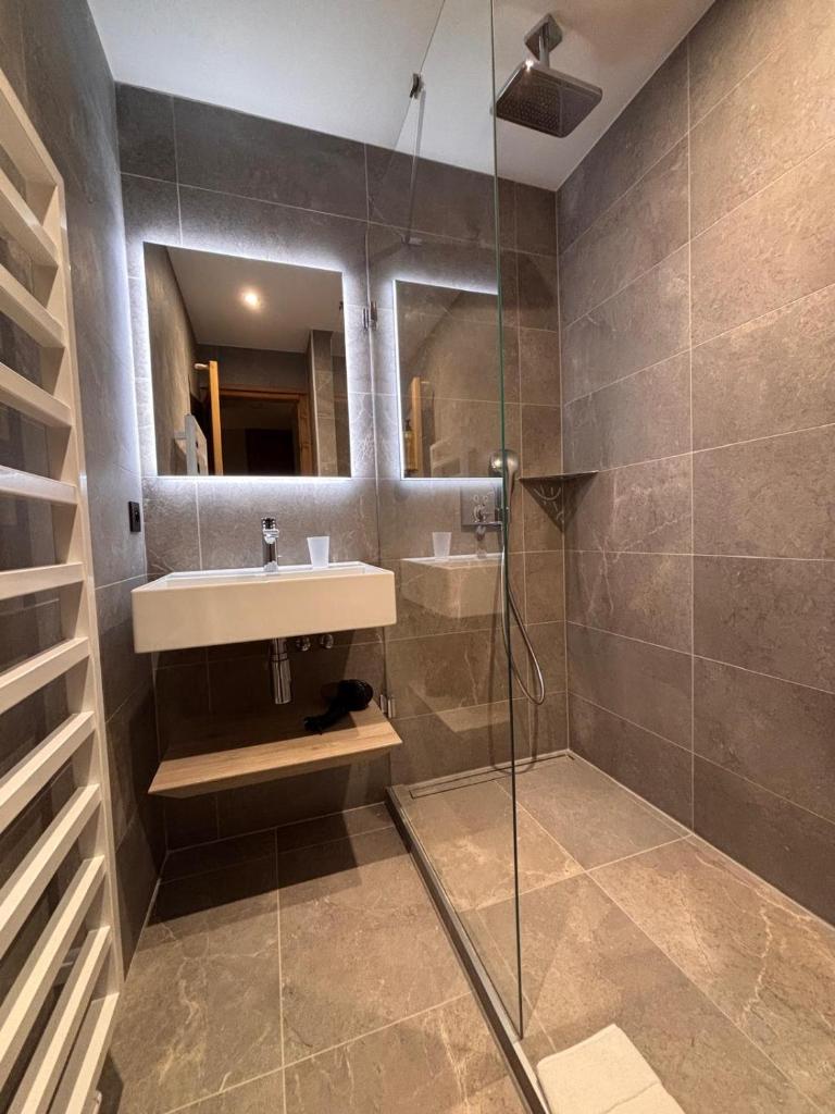 une salle de bain avec un lavabo et une douche en verre dans l'établissement Résidence Frond'Neige, à Morzine 35 autres photos