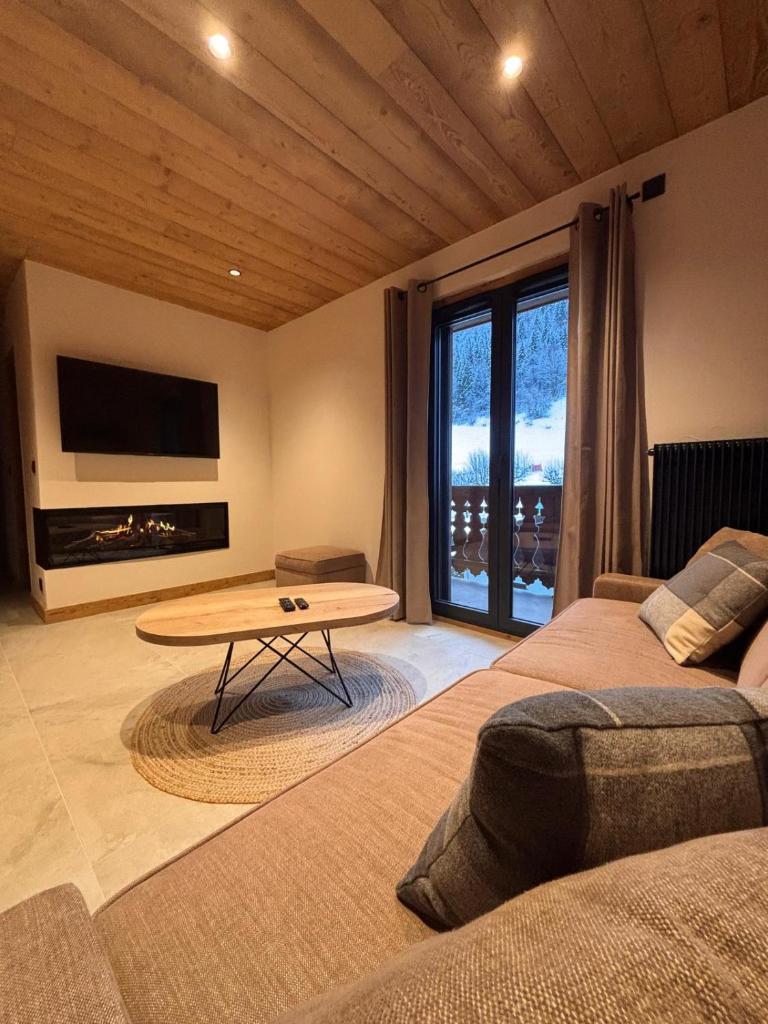 un salon avec une table et une grande fenêtre dans l'établissement Résidence Frond'Neige, à Morzine