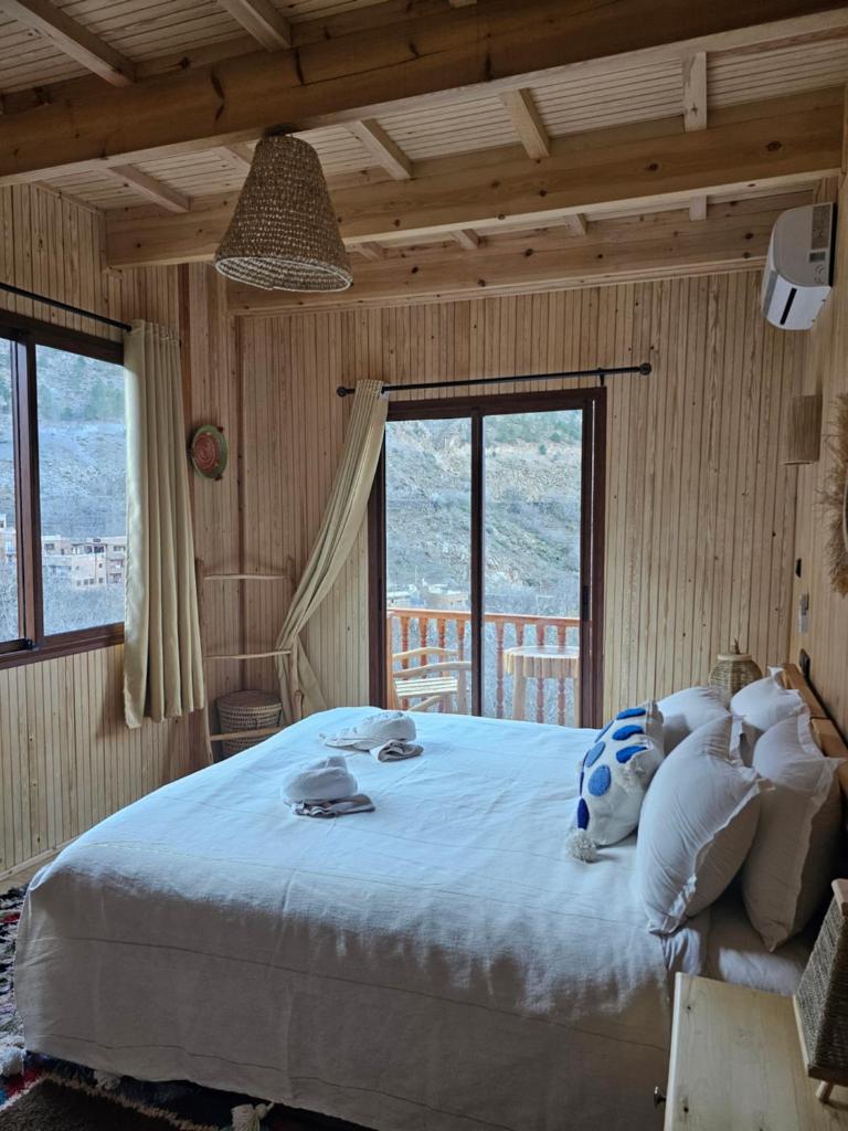 - une chambre avec un grand lit dans une pièce dotée de fenêtres dans l'établissement Jnane Karma, à Imlil