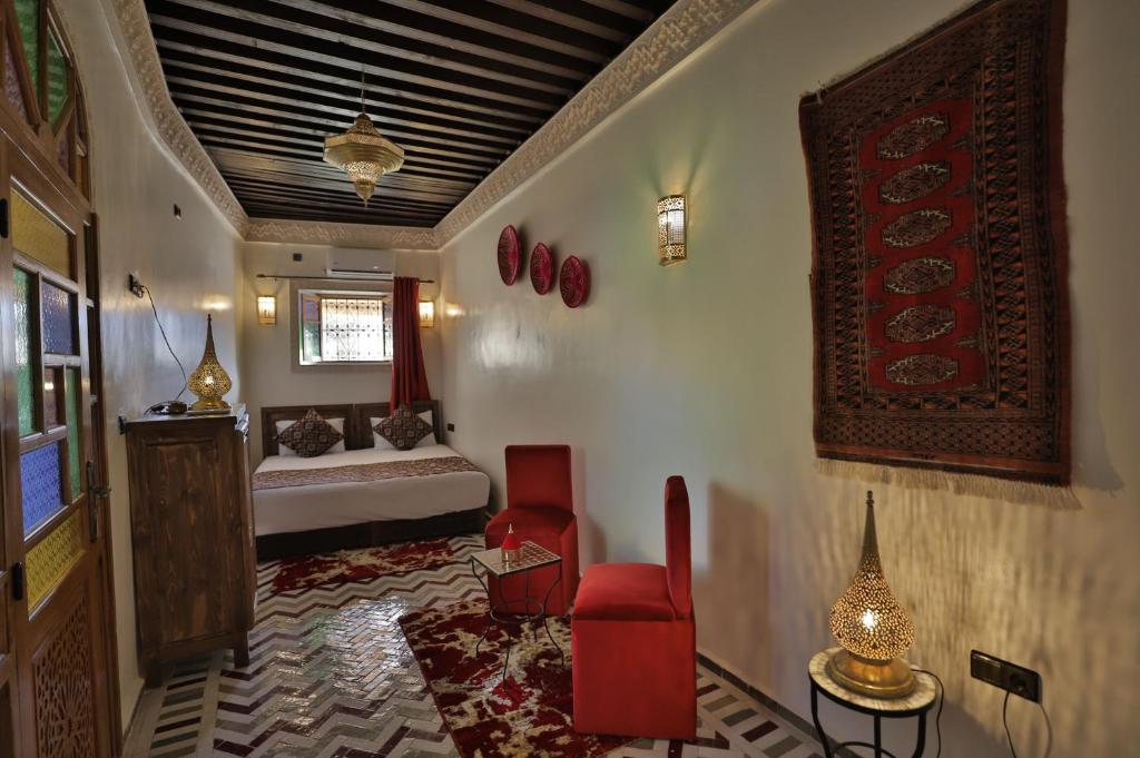 - un salon avec un lit et une chaise rouge dans l'établissement Dar derb el miter, à Fès