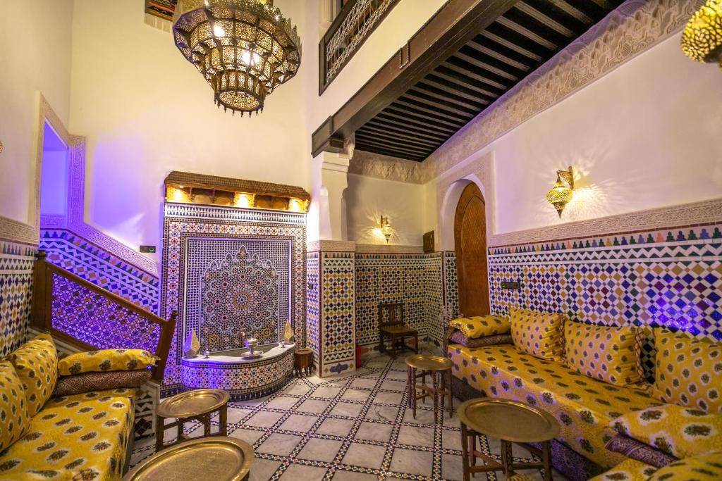 une chambre avec des canapés, des tables et un lustre dans l'établissement Dar derb el miter, à Fès