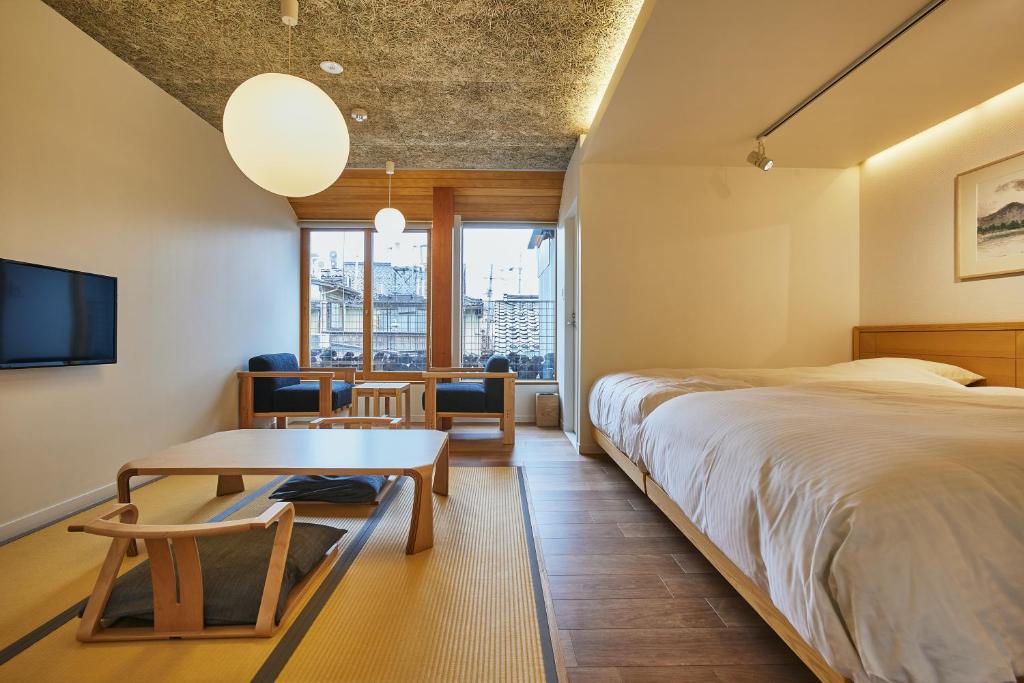 une chambre avec un grand lit et une table dans l'établissement TSUCHIYA Kinosaki onsen, à Toyooka