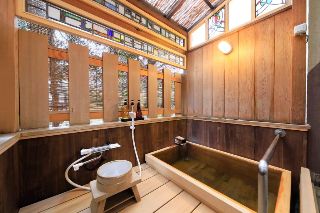 une salle de bain avec baignoire et toilettes dans l'établissement Kamiyamada Hotel, à Chikuma
