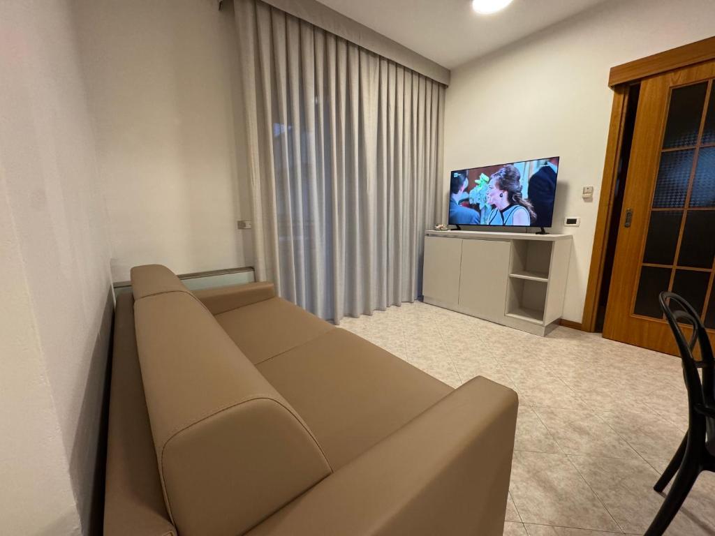 un salon avec un canapé et une télévision dans l'établissement Residence le Spiagge, à Rimini